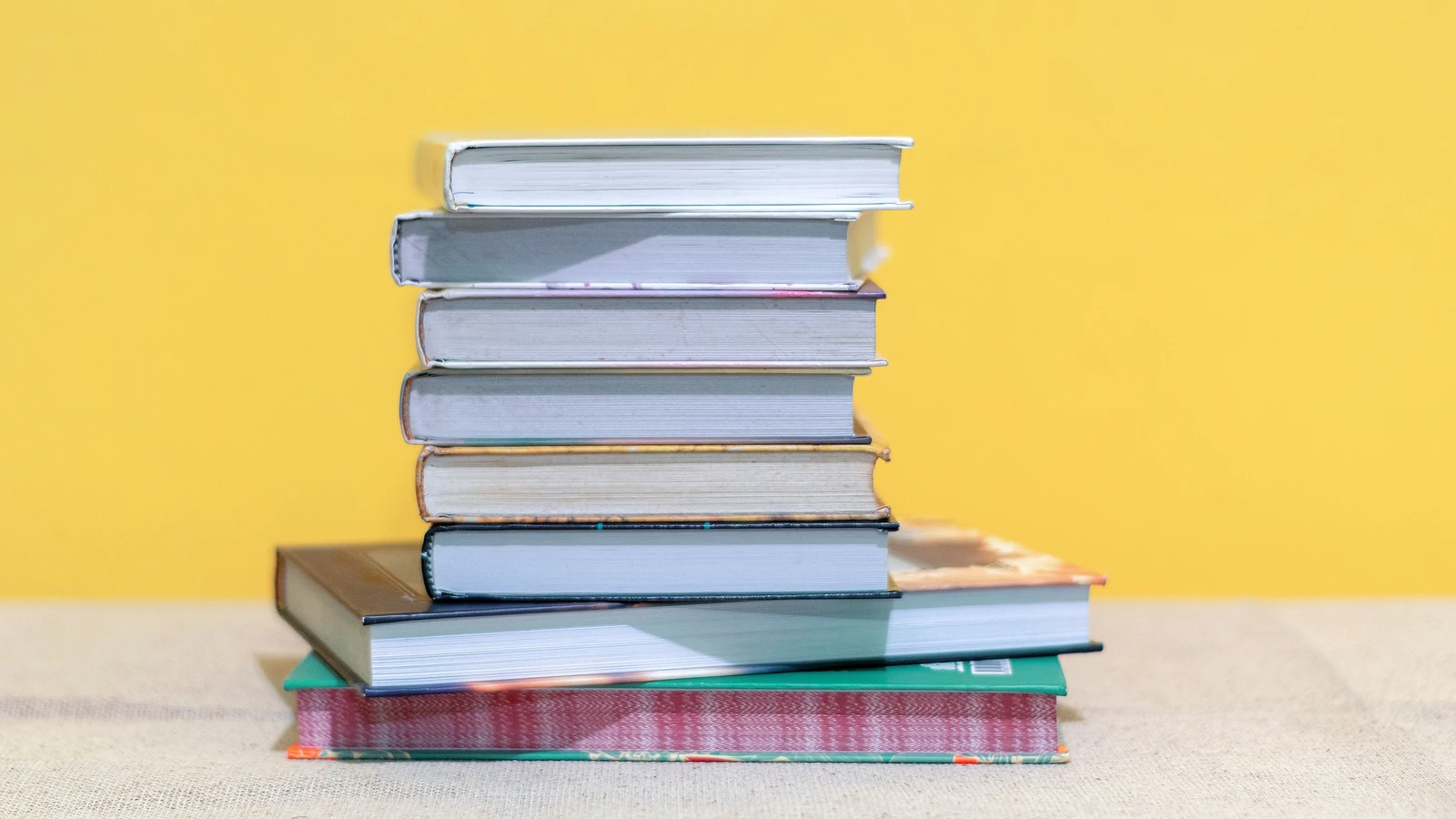 Pilha de livros sobre fundo amarelo
